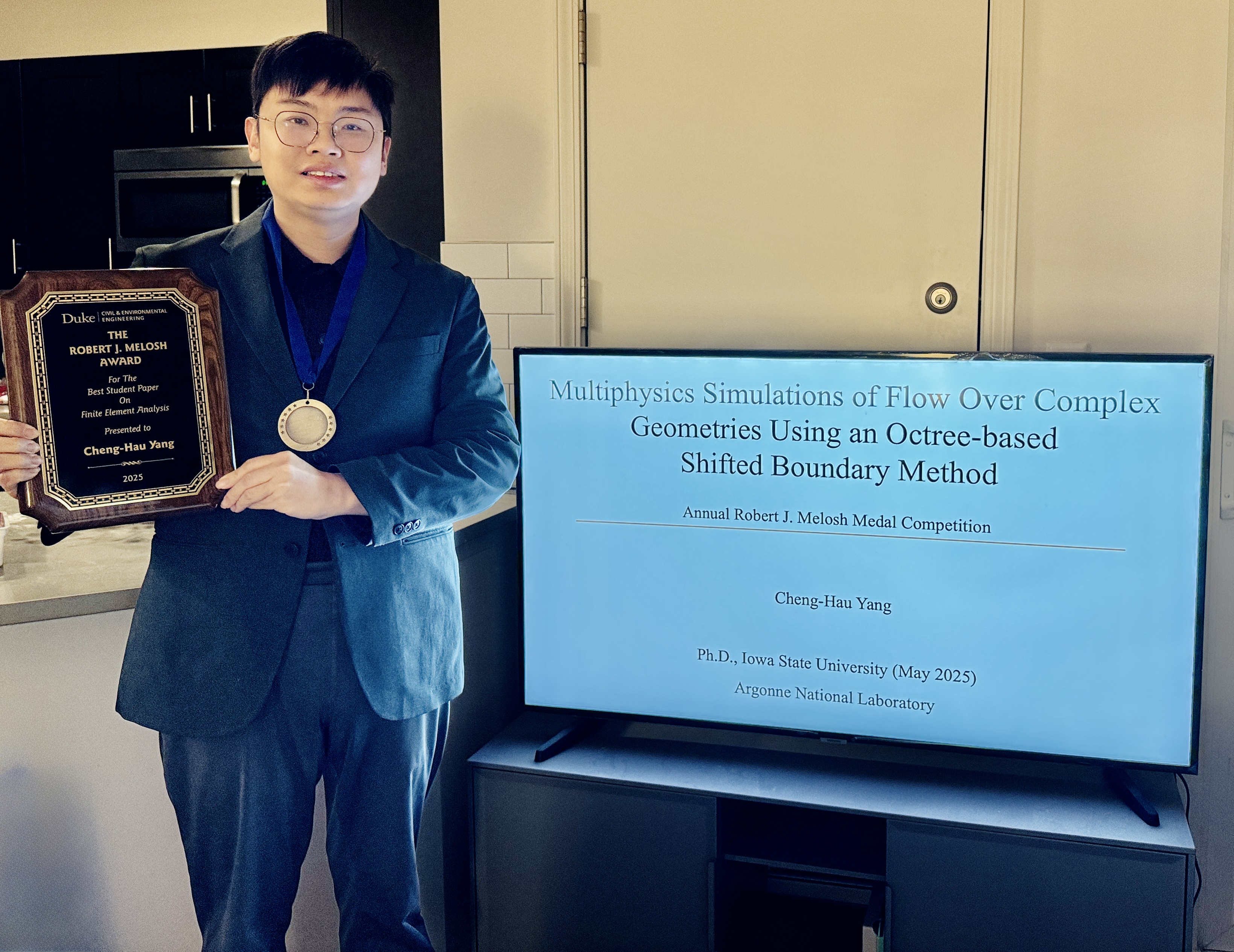 Cheng-Hau Yang holding the Robert J. Melosh Medal plaque
